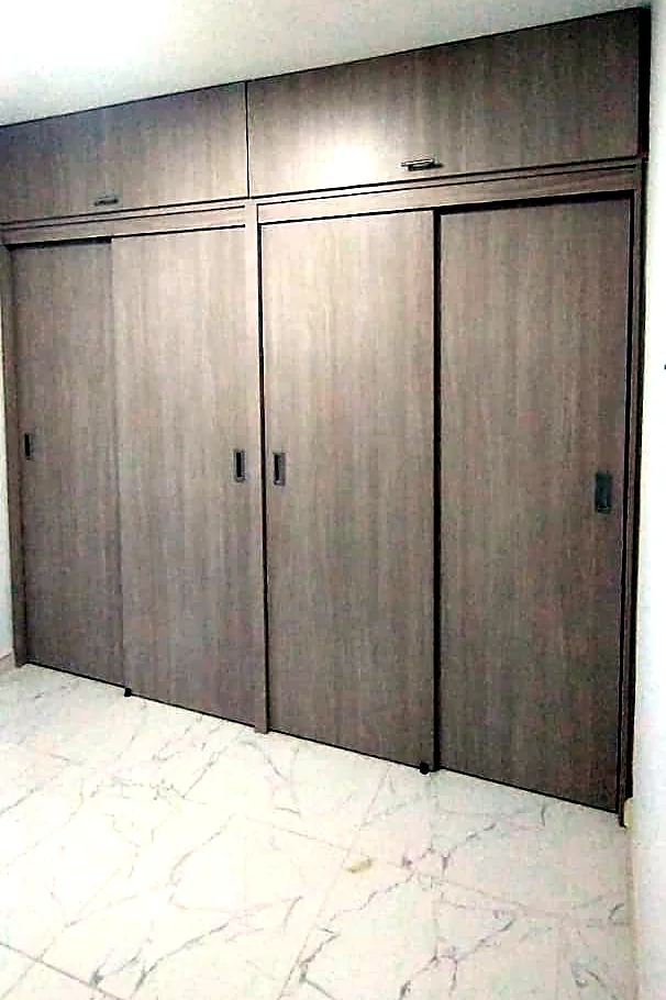 Clóset de pared a pared con puertas corredizas y maletero